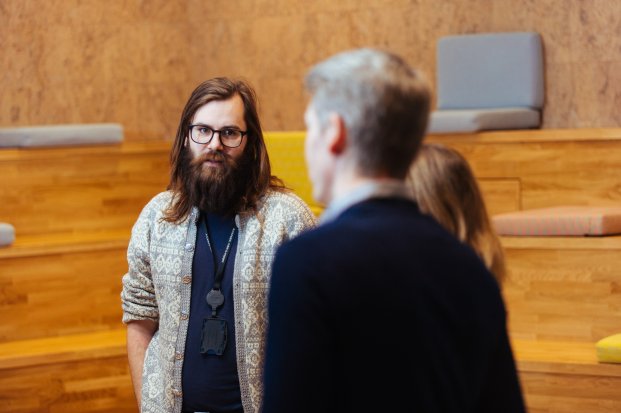 Bearded man talking to two colleagues