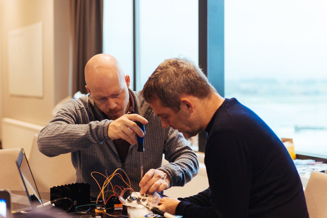Photo of two men working on assembling computer parts