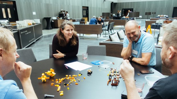 People smiling while building something with LEGO during a workshop at Equinor Developer Conference