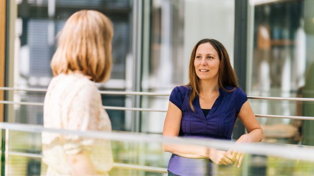 Two women talking together inside an Equinor office building