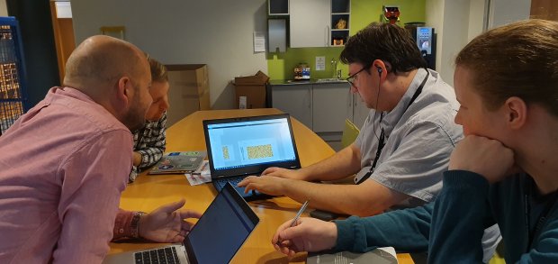 A team of software developers in Equinor working together in a meeting room