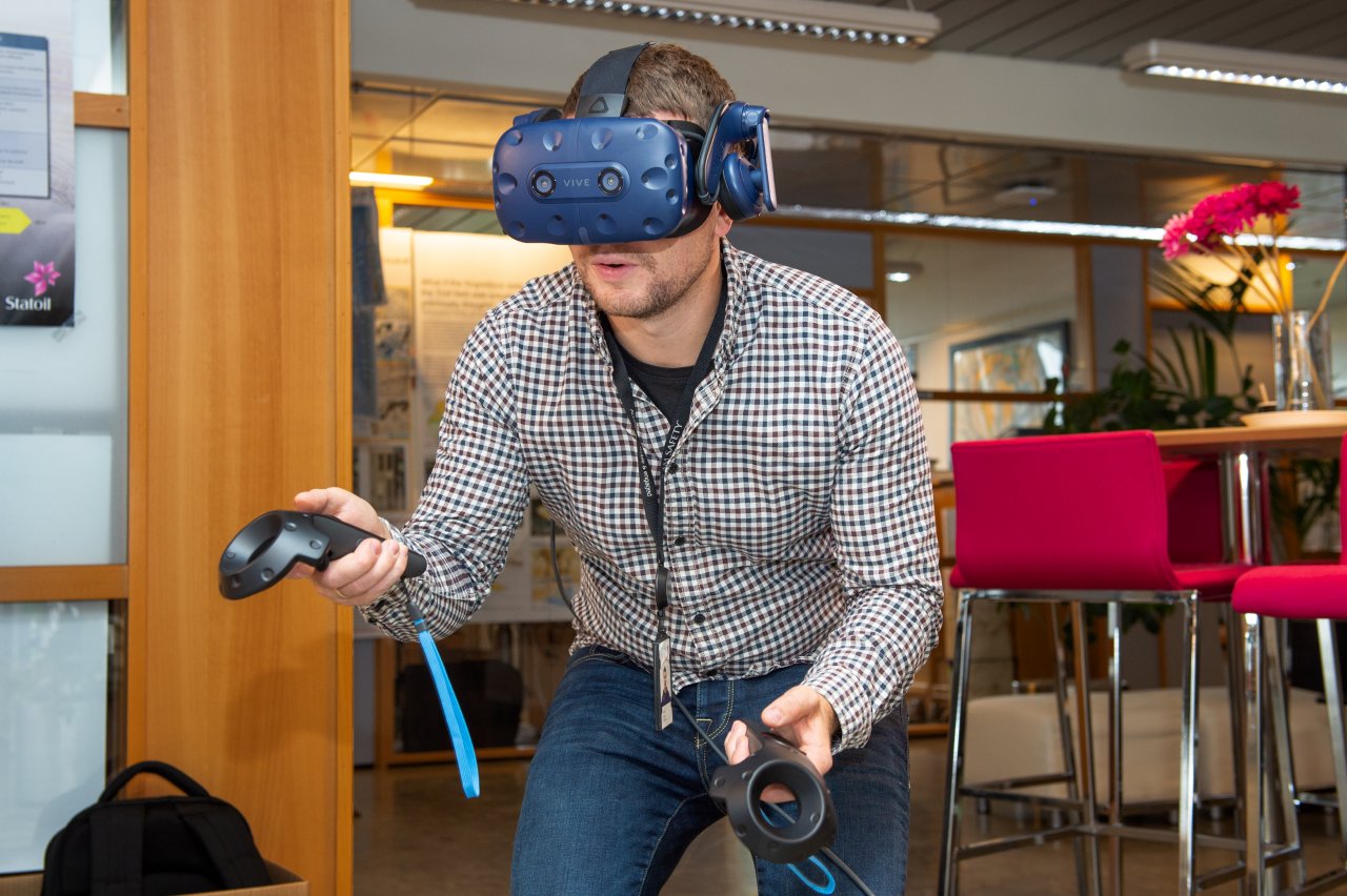 Man wearing a VR headset and kneeling in an office landscape
