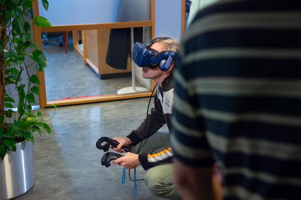 Man kneeling while wearing a VR headset