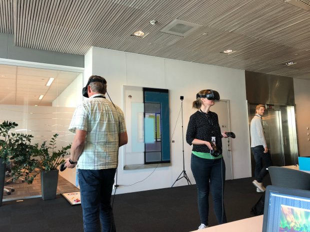 Two people wearing VR headsets in an office landscape