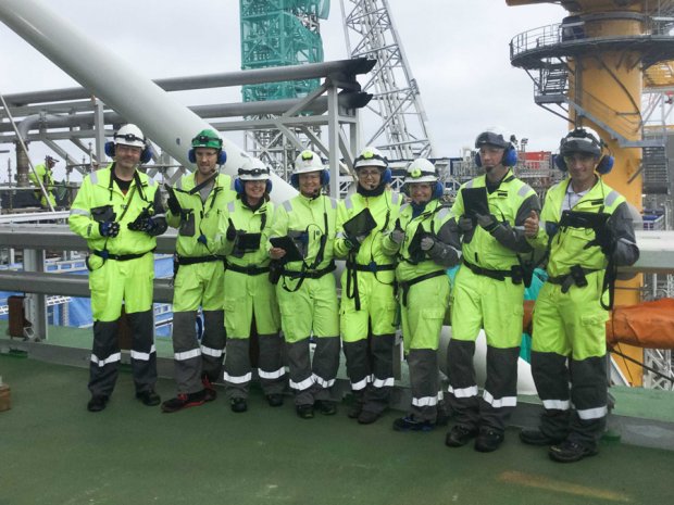 Group of smiling WorkPermit app users standing and giving thumbs up on an oil platform offshore
